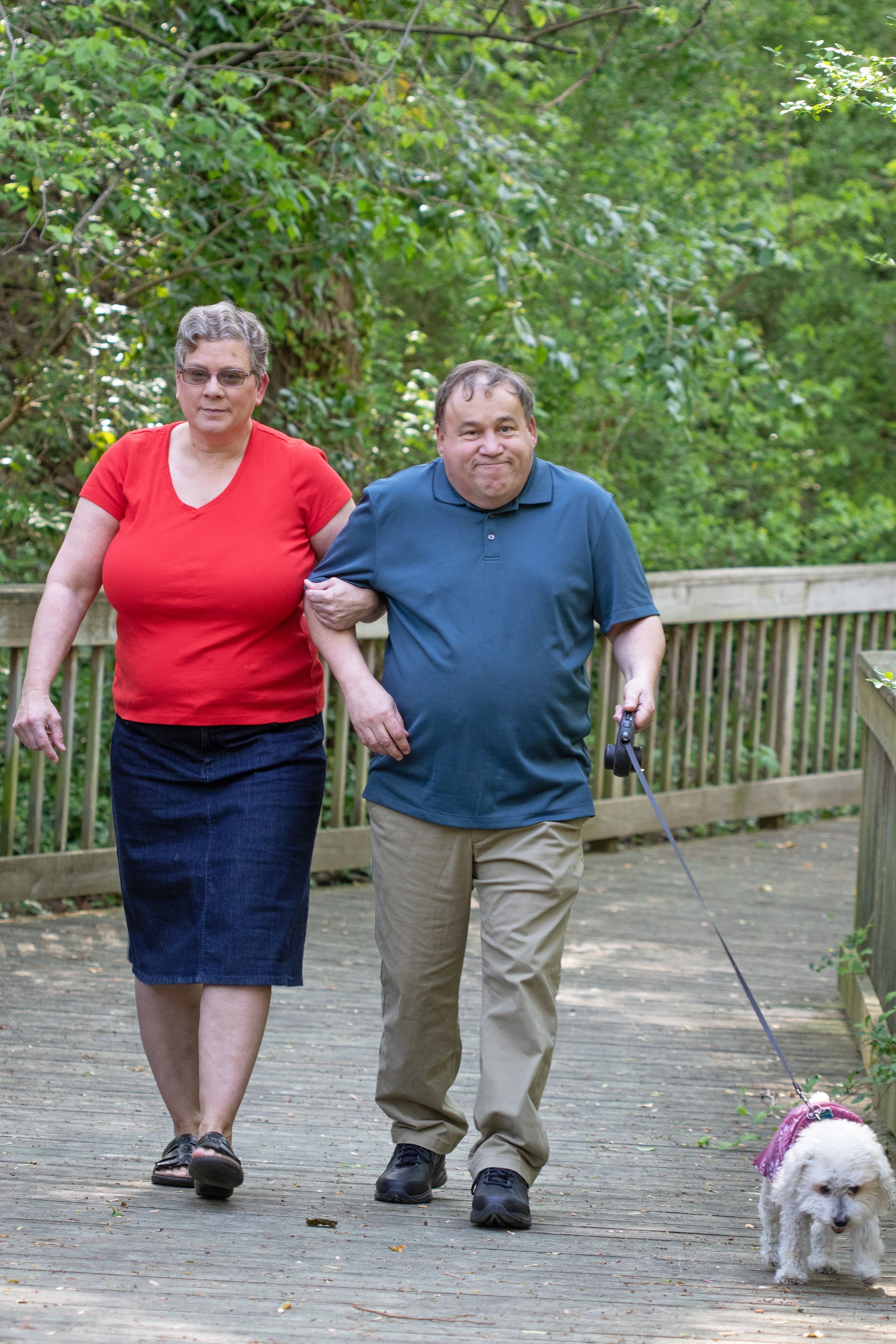  Autistic adult man walking a dog with his sister and caregiver—highlighting sibling caregiving, autism support, and inclusive community living for adults with developmental disabilities