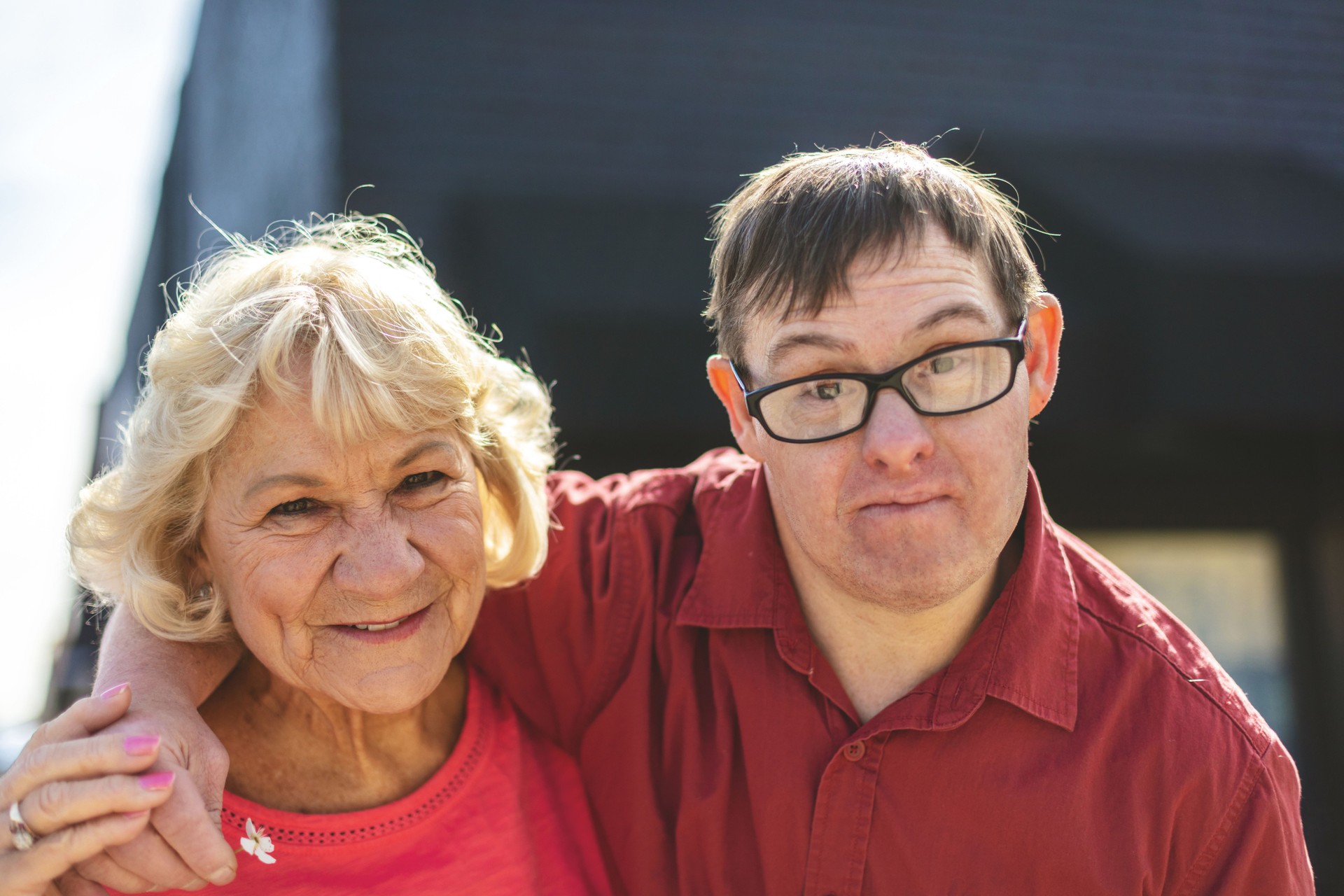  Aging mother standing beside her adult son with Down syndrome—highlighting long-term care planning, disability support, and future transition for aging caregivers of adults with disabilities