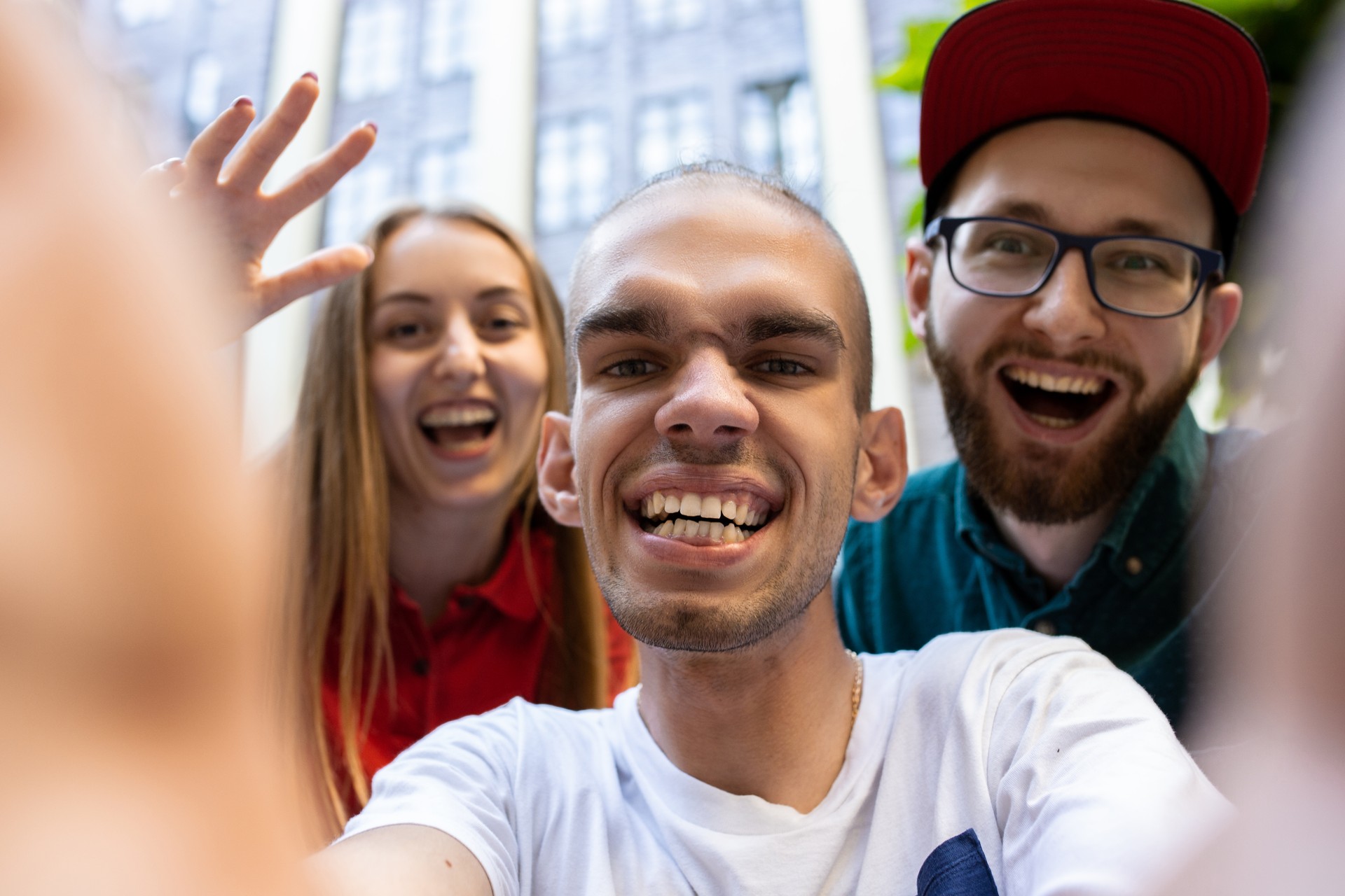 Group of friends taking a stroll on city's street in summer day