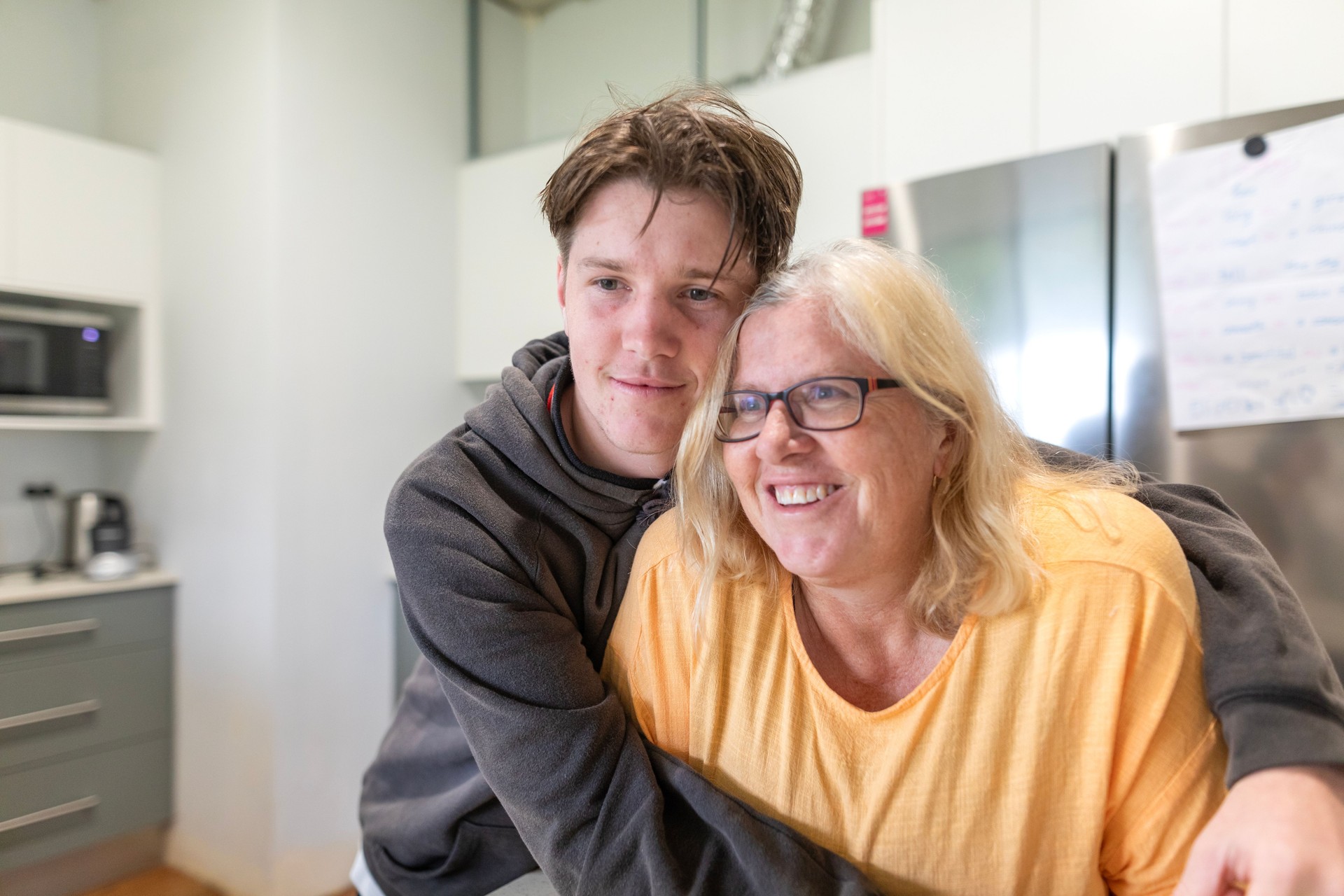 Teenage son with developmental disabilities hugging his aging mother—capturing the emotional bond, caregiver support, and need for long-term planning for families of individuals with disabilities